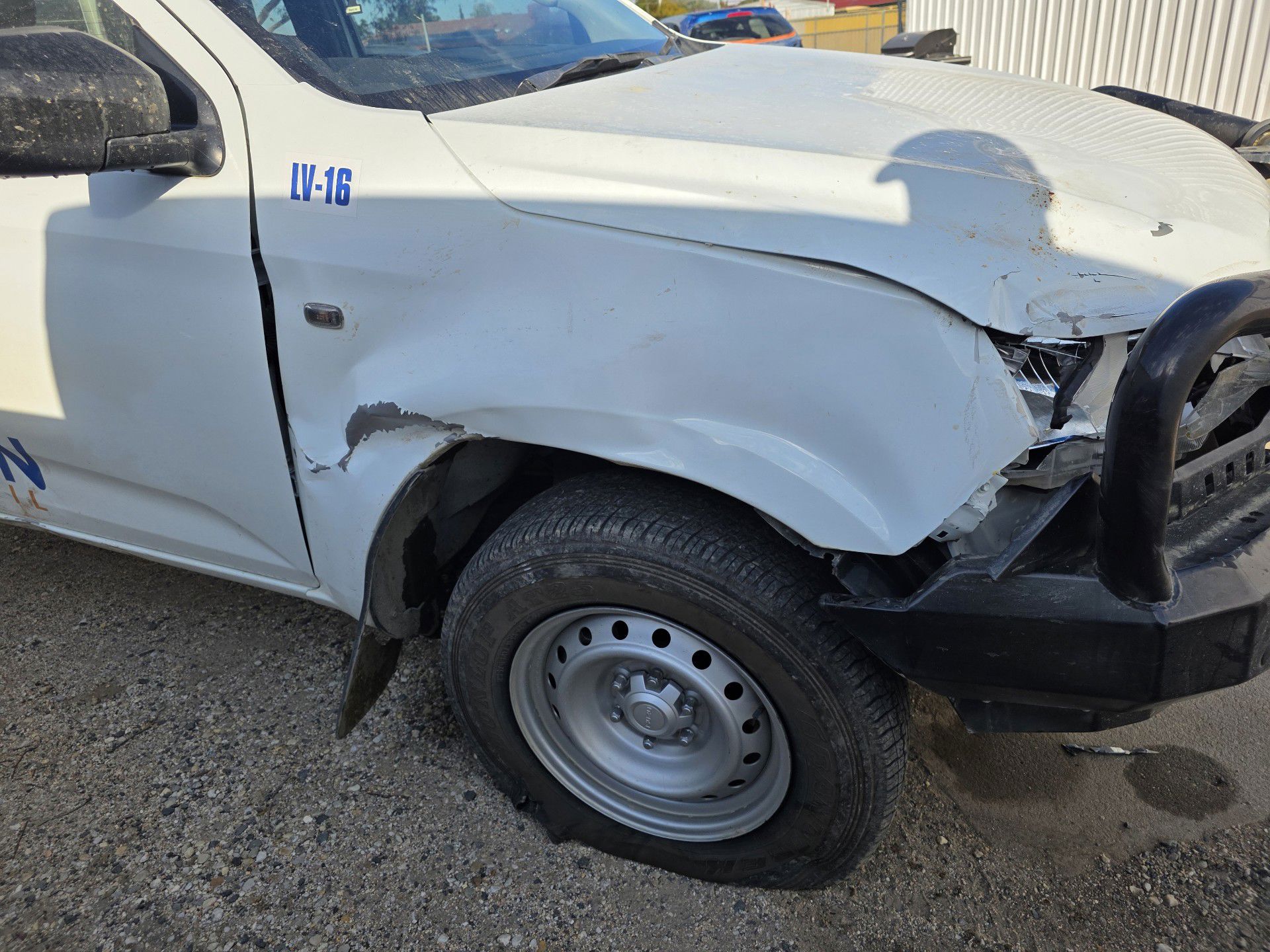 White Isuzu D-Max with front-end collision damage awaiting repair