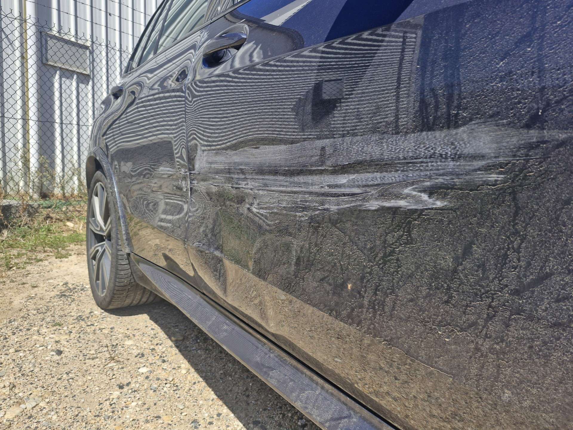 Deep scratches along the side doors of a grey BMW X5